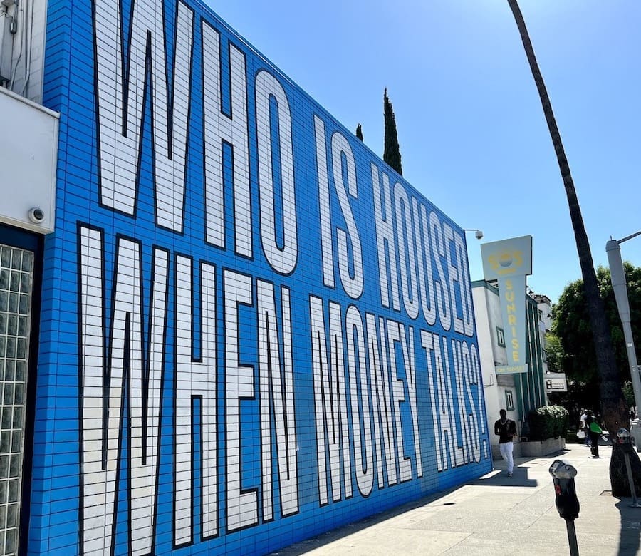 Featured image for “Barbara Kruger Mural in LA Asks, ‘Who Is Housed When Money Talks?’”
